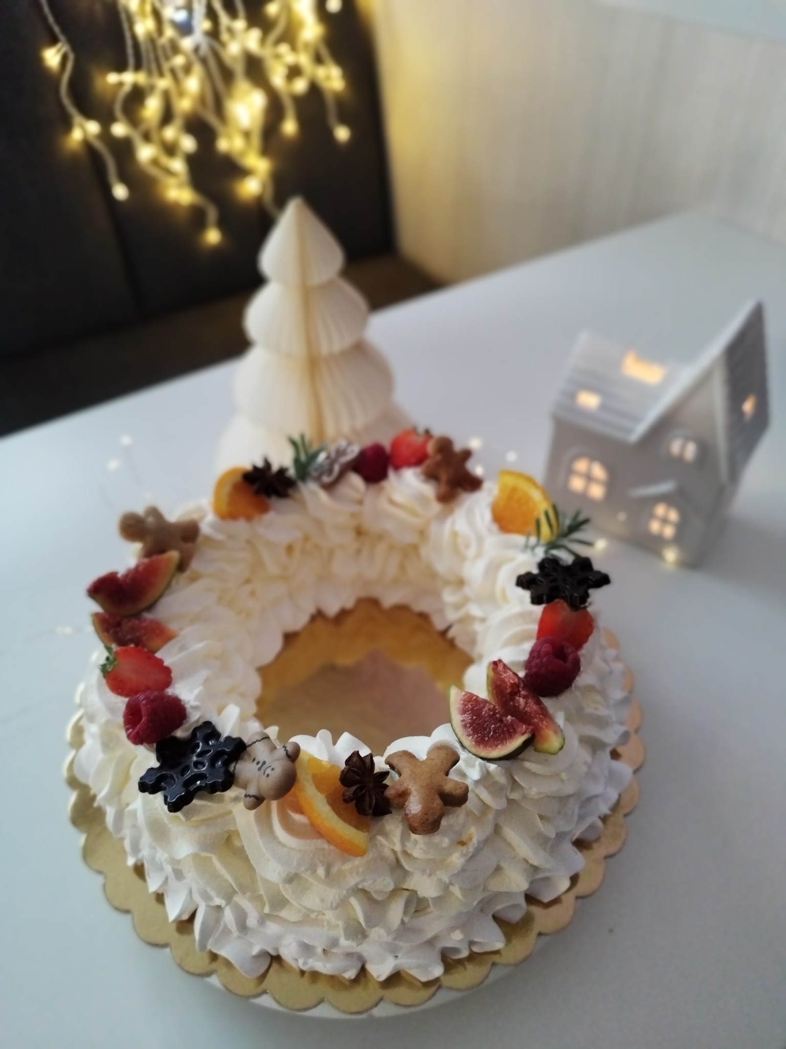 Vánoční rodinná pavlova ve tvaru věnce s ovocem a svátečními ozdobami